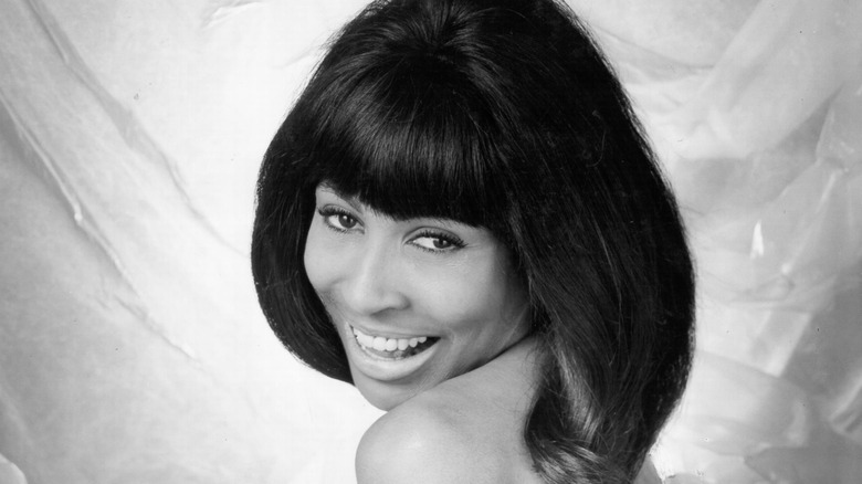 Tina Turner smiling over shoulder