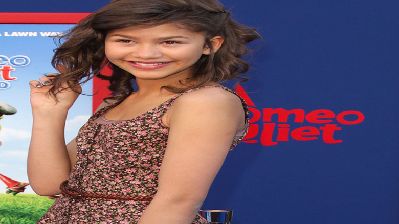 Zendaya smiling on the red carpet as a child.