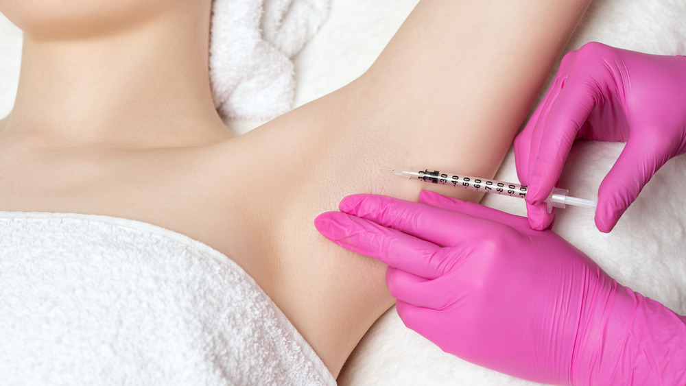 A woman receiving a Botox injection in her armpit 