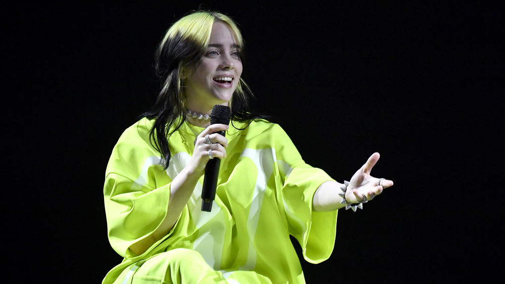 Billie Eilish singing in green shirt