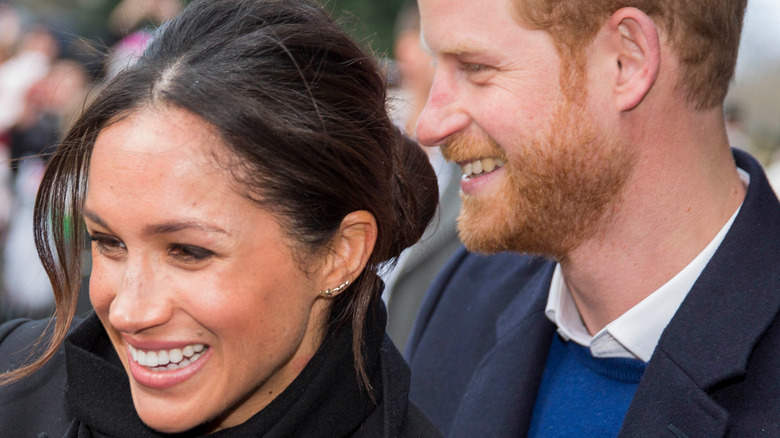 Meghan and Harry smile and greet fans