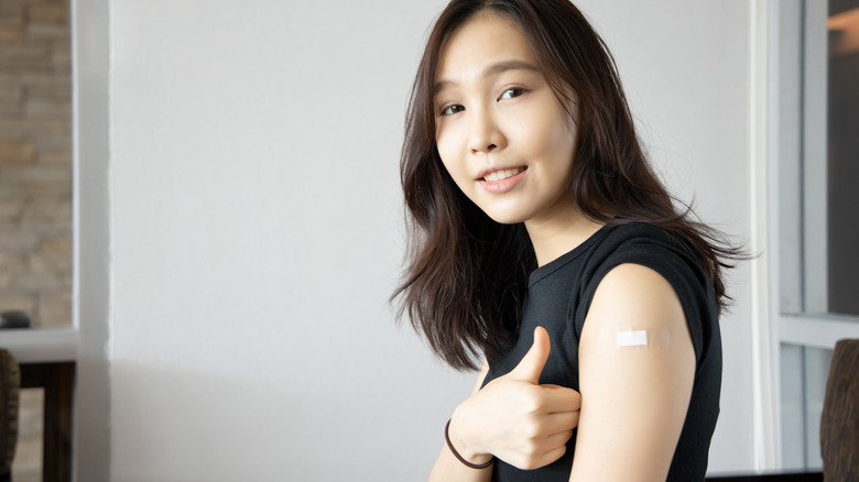 woman giving thumbs up after vaccine