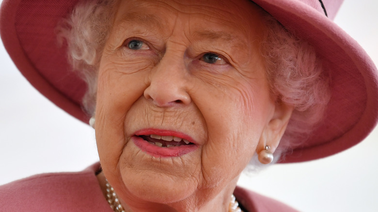 Queen Elizabeth II wearing pink hat with slight smile