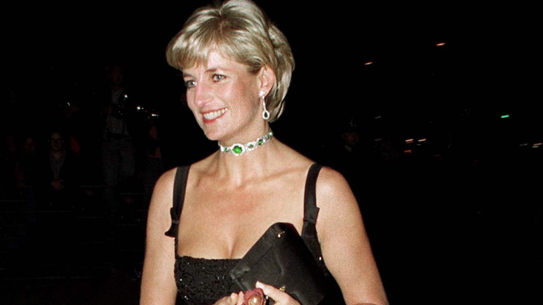 A smiling Princess Diana attending an event in a black dress