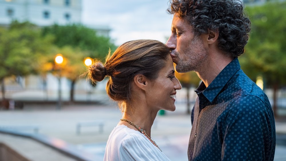 Man kissing woman on the forehead