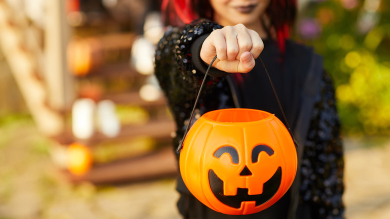 Trick-or-treater holding candy bucket