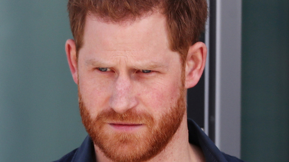 Prince Harry looking serious with facial hair