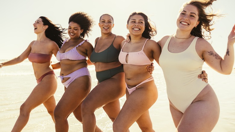 women in swimwear walking on beach