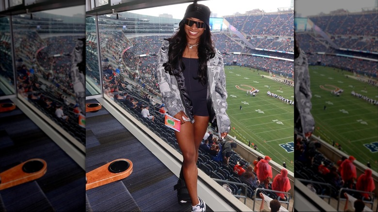 Simone Biles posing in front of a football field