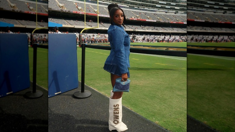 Simone Biles posing on a football field in all denim