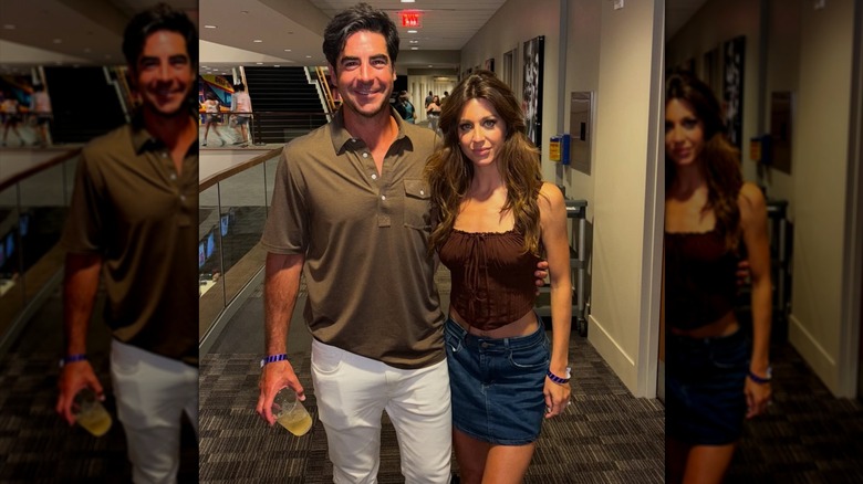 Smiling Jesse Watters with a drink in his hand placing his arm around Emma Watters