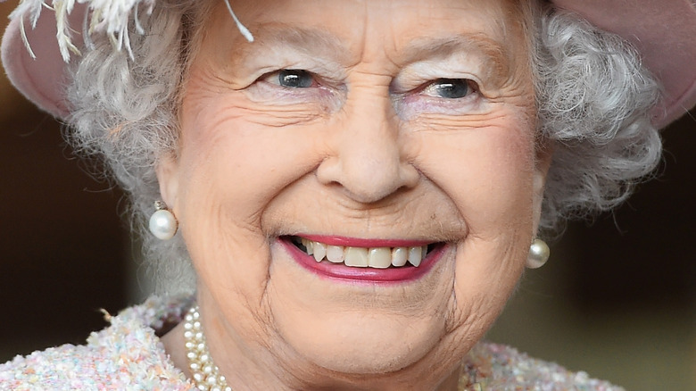 Queen Elizabeth II smiling and looking to the side