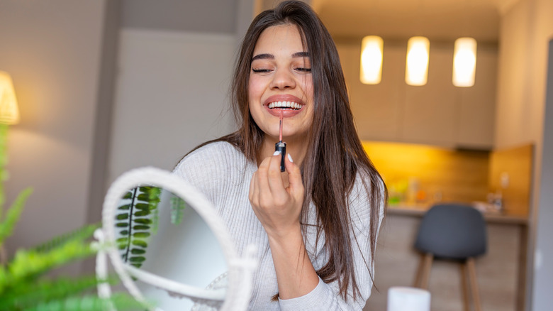 Woman applying lipstick