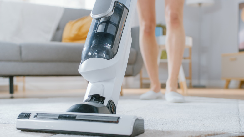 Woman vacuuming a rug. 