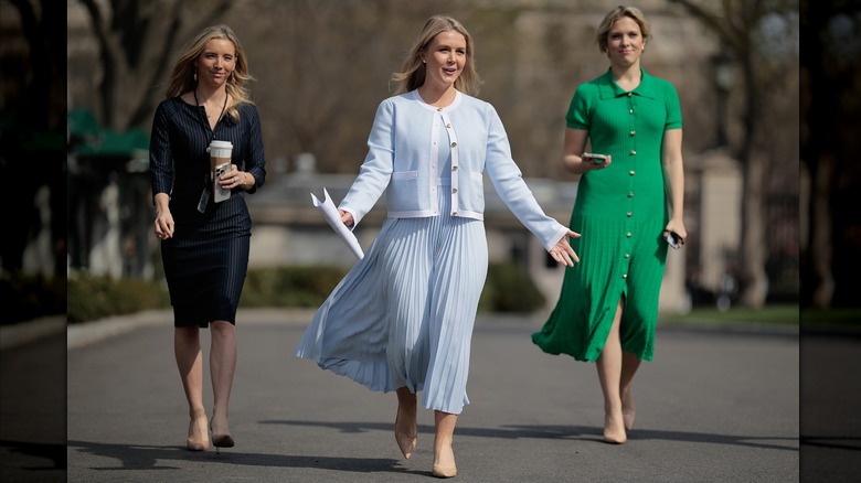 Karoline Leavitt walking pale blue sweater and pleated skirt
