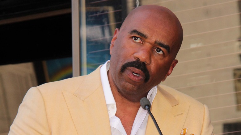Steve Harvey speaking into a microphone