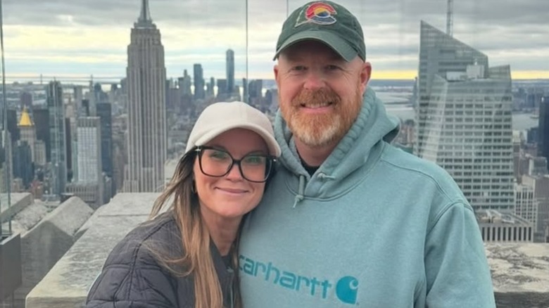 Leslie Davis and Don Reidy smiling in front of reflected New York City