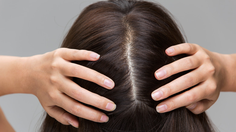 A woman parting her hair with her hands 