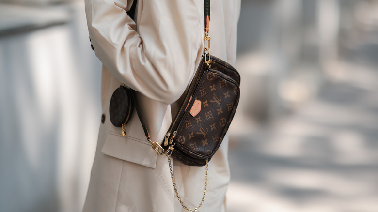 Woman carrying a small Louis Vuitton bag