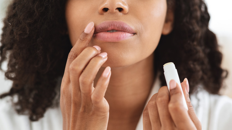 Woman applying lip balm to lips