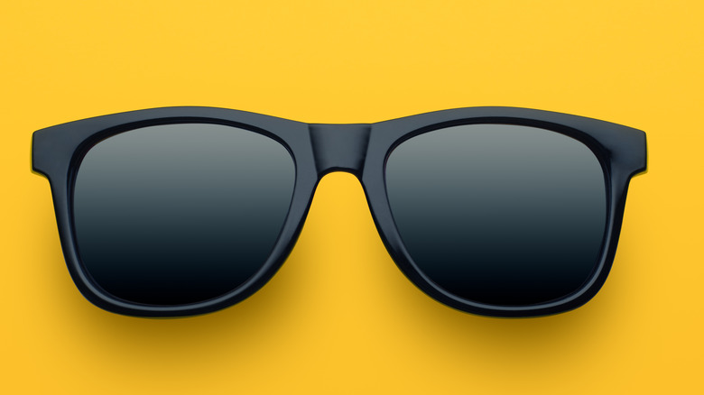 black sunglasses on a yellow background 