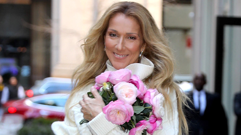 Celine Dion smiling, holding flowers