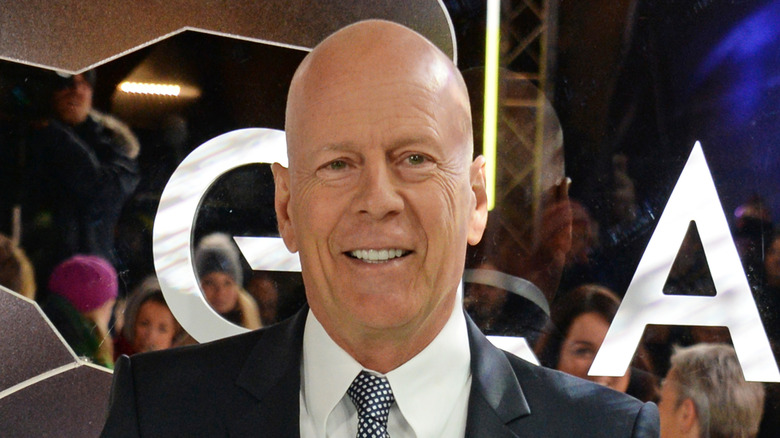 Bruce Willis smiling at the premiere of 'Mr. Glass' while in a suit.