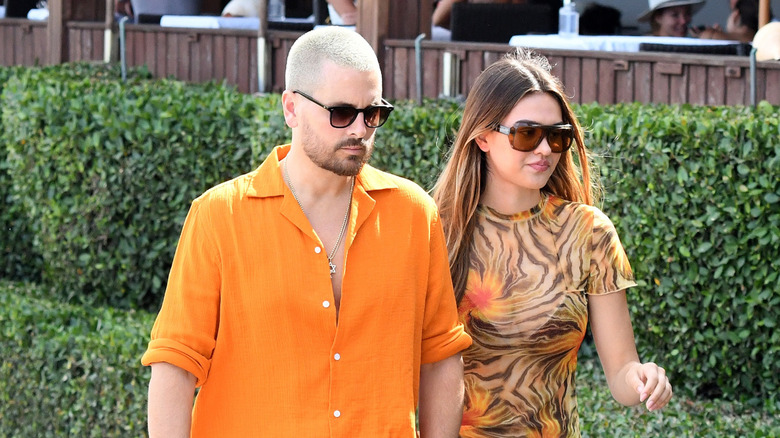 Scott Disick walking outside with Amelia Gray Hamlin in 2021