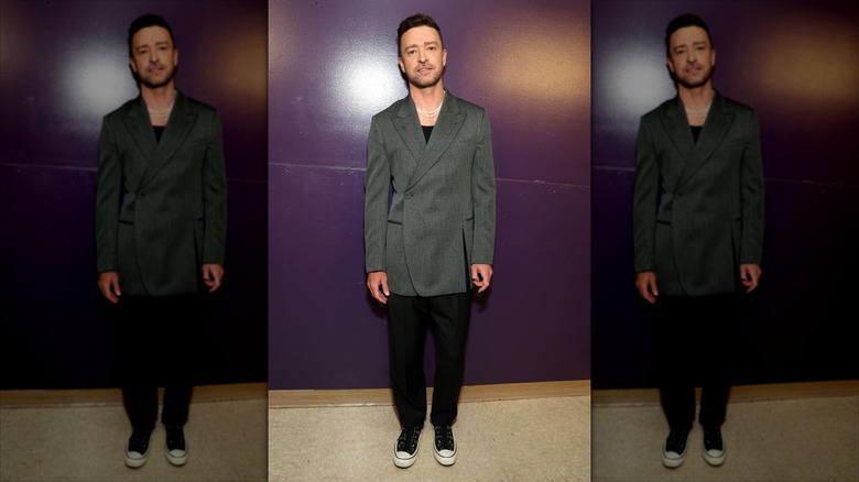 Justin Timberlake in front of a purple wall wearing an oversized grey blazer