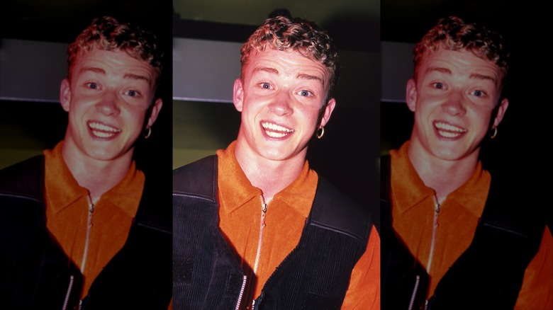 A teenage Justin Timberlake in orange, sporting a big hoop earring in one ear