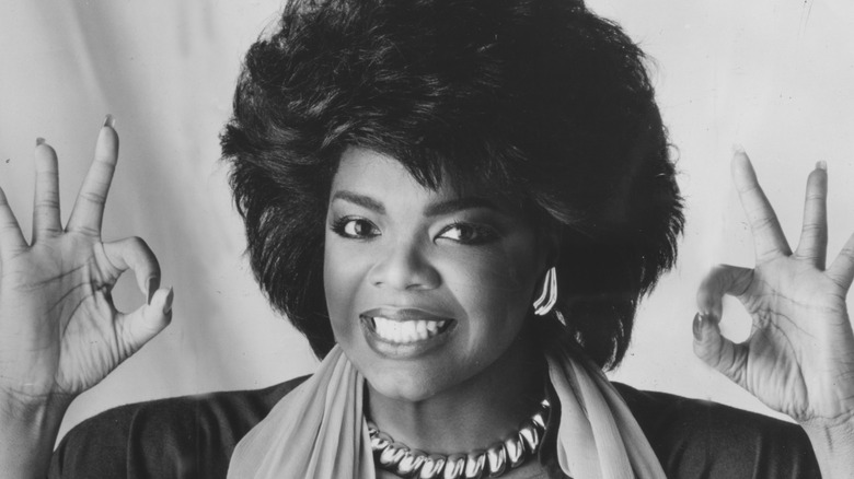 Oprah Winfrey smiling and making the OK gesture with both hands