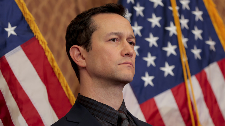 Jospeh Gordon-Levitt solemnly posing in front of some American flags