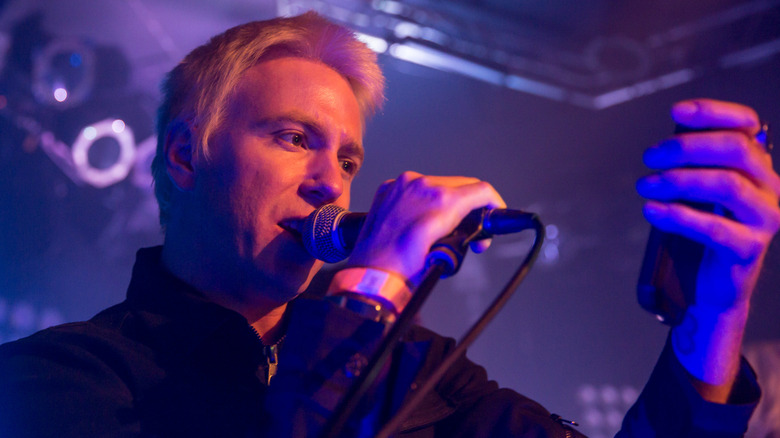 Elijah Blue Allman singing in his band, Deadsy, during a 2013 performance while looking at his phone