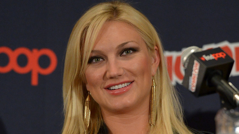 Closeup of Brooke Hogan smiling in front of mic on panel