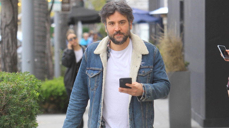 Josh Radnor walking around in Los Angeles, phone in hand