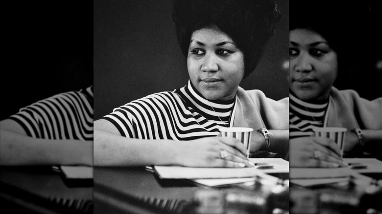 Aretha Franklin looks off in the distance while in the studio