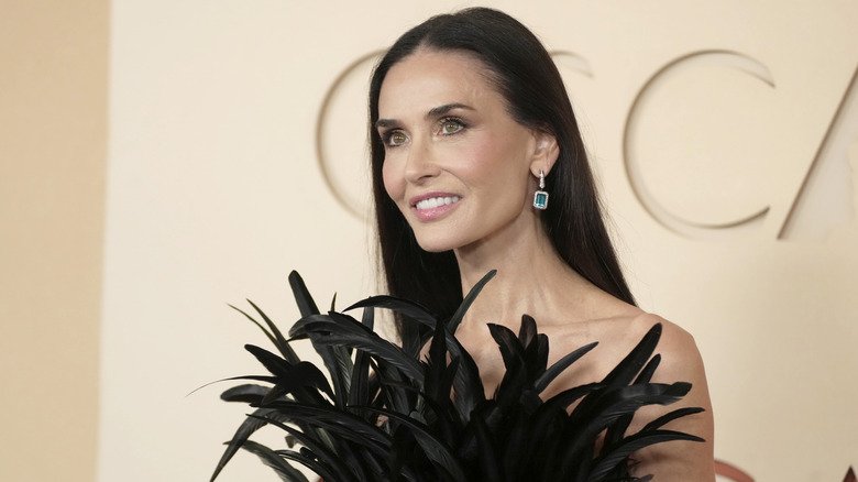 Demi Moore posing in her feathered dress at the 2026 Oscars Red Carpet