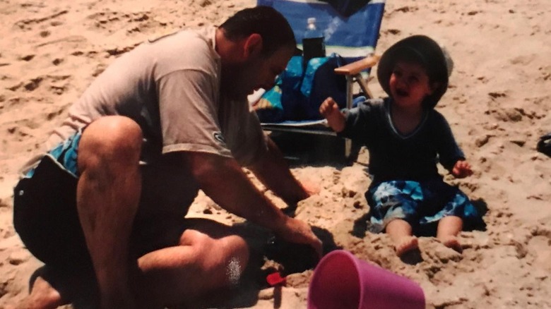 James Gandolfini and an infant, smiling Michael Gandolfini building a sandcastle