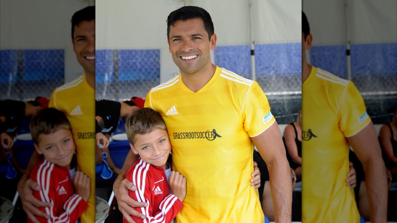 Kelly Ripa and Mark Consuelos' son Joaquin Consuelos smiling as a child and holding his dad's waist