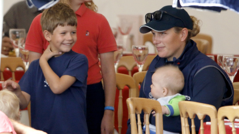 Zara Phillips, with daughter Mia Tindall, jokes with her cousin James, Viscount Severn (son of Prince Edward, Earl of Wessex & Sophie, Countess of Wessex) as she attends day 2 of the Festival of British Eventing at Gatcombe Park on August 2, 2014 in Minchinhampton, England.