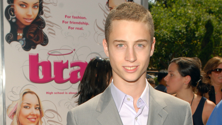 Chet Hanks posing in front of a Bratz poster at the film's premiere