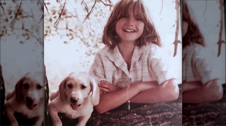 A young Kristi Noem posing with her dog