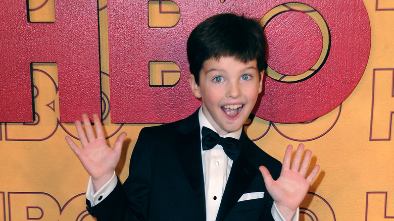 Iain Armitage grinning and flashing jazz hands at an Emmy Awards reception