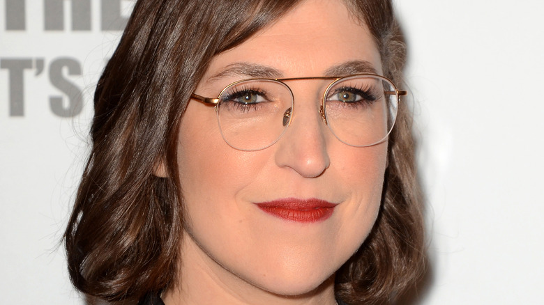 Mayim Bialik in glasses wearing red lipstick