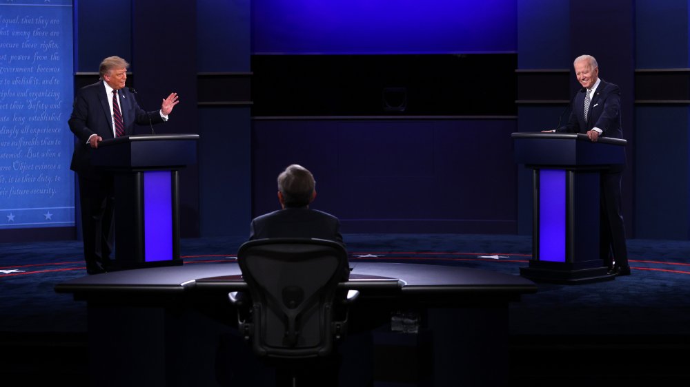 Debate stage wide shot with debaters, moderator