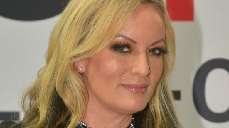 Stormy Daniels giving a sly, steely look