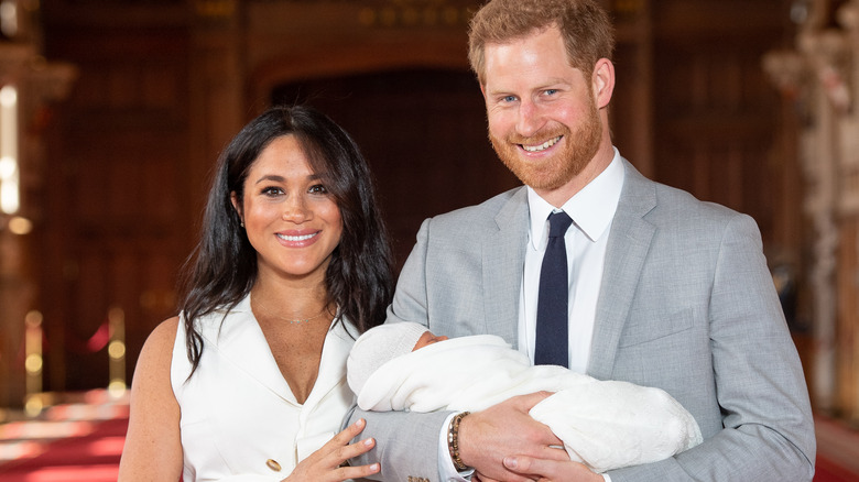 Harry holding baby Archie alongside Meghan