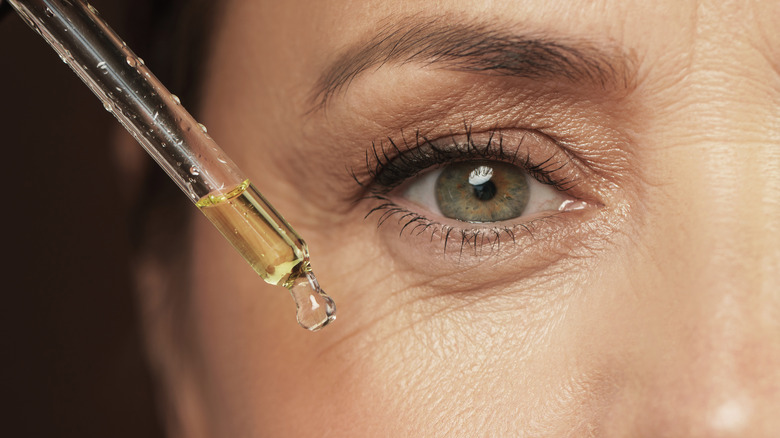 Serum dropper next to woman's undereye