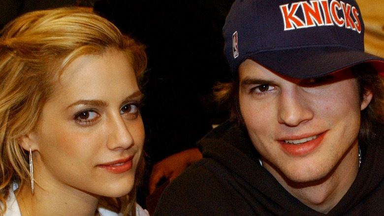 Brittany Murphy and Ashton Kutcher smiling together at the 2003 NBA All-Star game