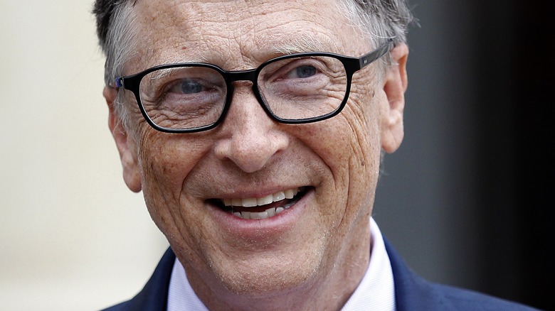 Bill Gates smiling in dark rimmed glasses